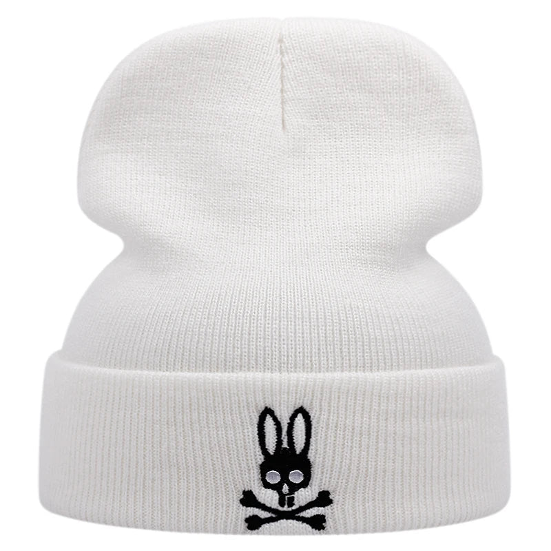 Ribbstickad vit mössa med svart kaninskalle och två korsade skelettben