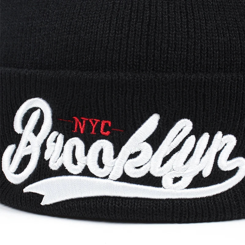 Ribbstickad svart mössa med texten BROOKLYN - NYC broderat i rött och vitt vid front