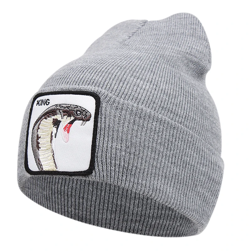 Grå mössa med kobra och texten king broderad på tygpatch