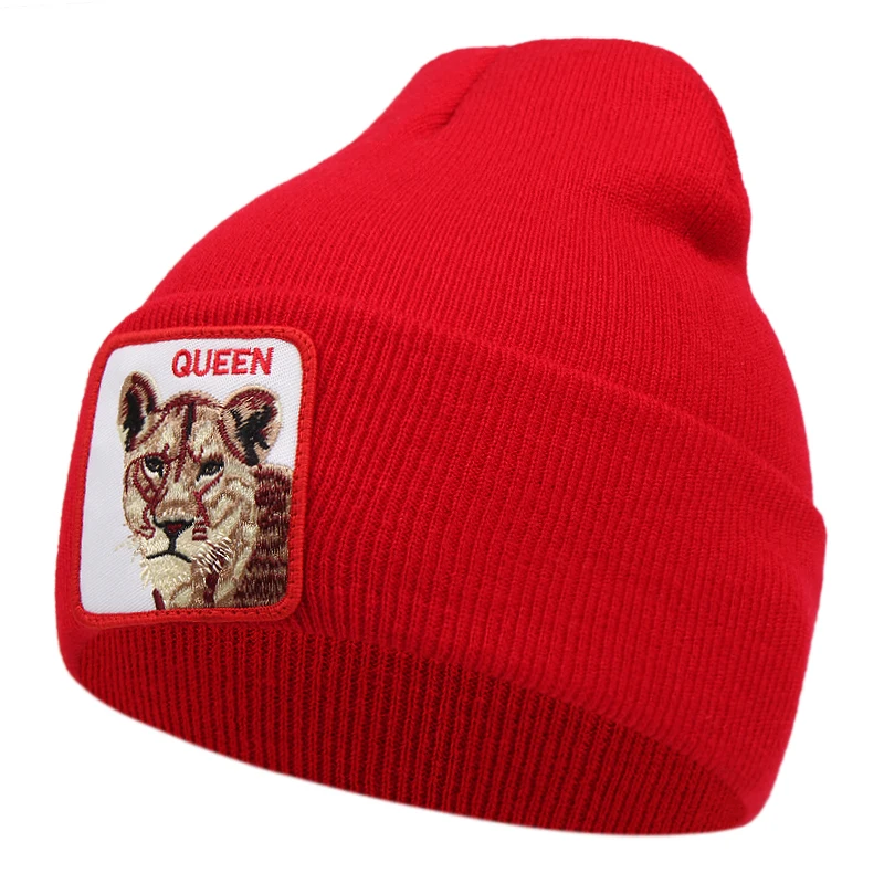Röd mössa med lejon och texten queen broderat på tygpatch