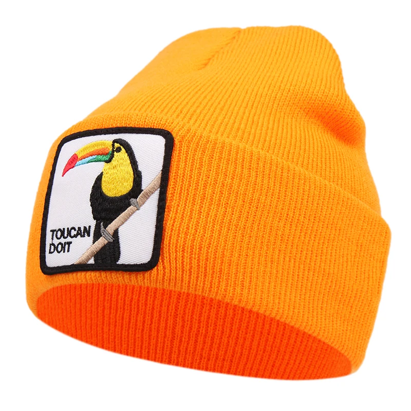 Orange mössa med fågelmotiv och texten toucan do it på framsidan