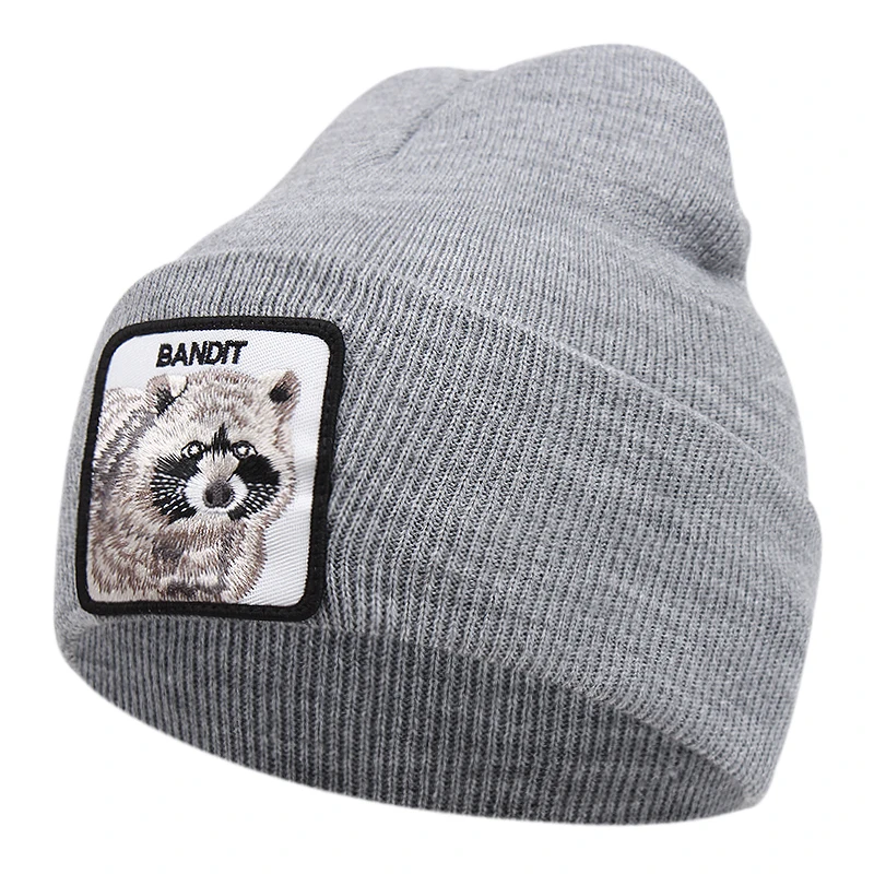Grå mössa med tvättbjörn och texten BANDIT broderad på tygpatch framtill