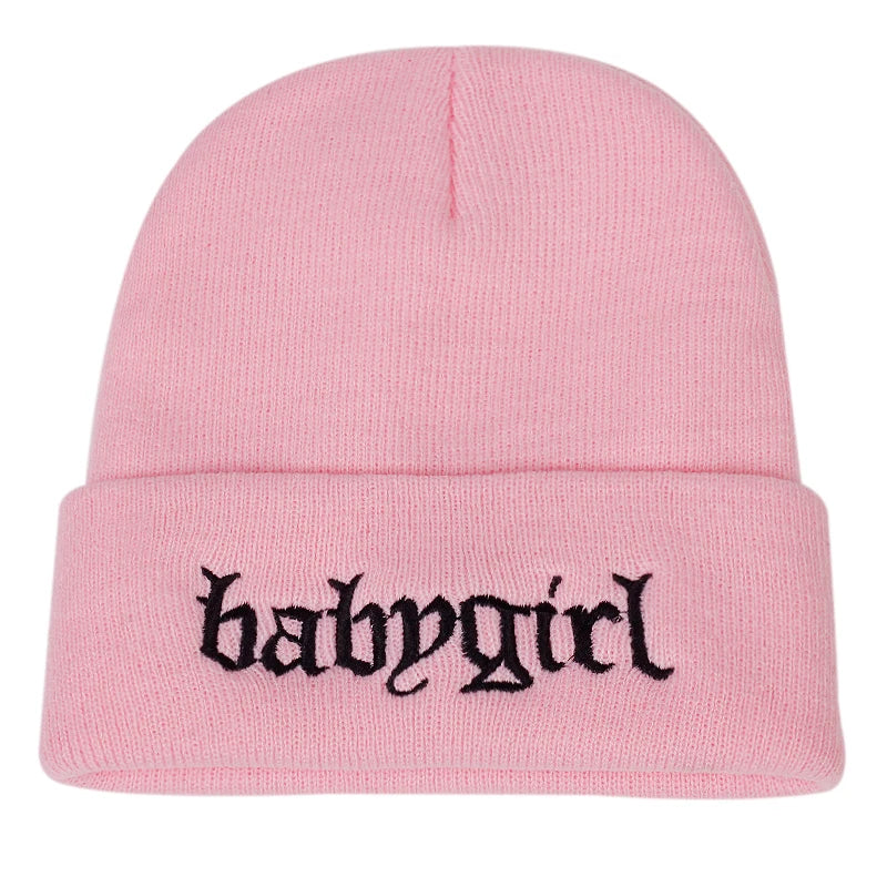 Ribbstickad rosa mössa med texten babygirl broderat i svart vid front