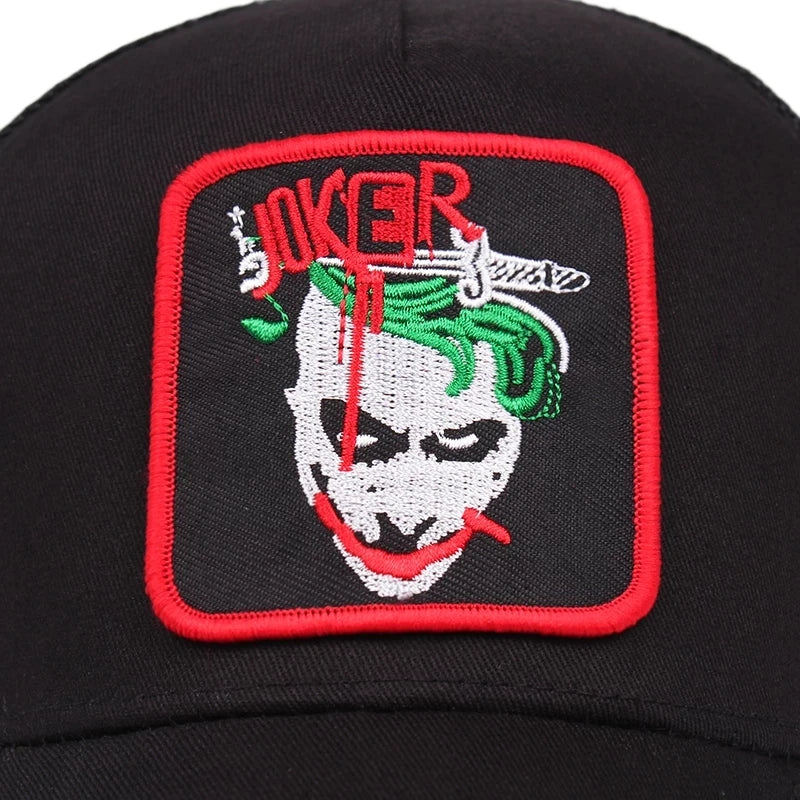 Svart keps med en joker och texten JOKER broderad på framsidan