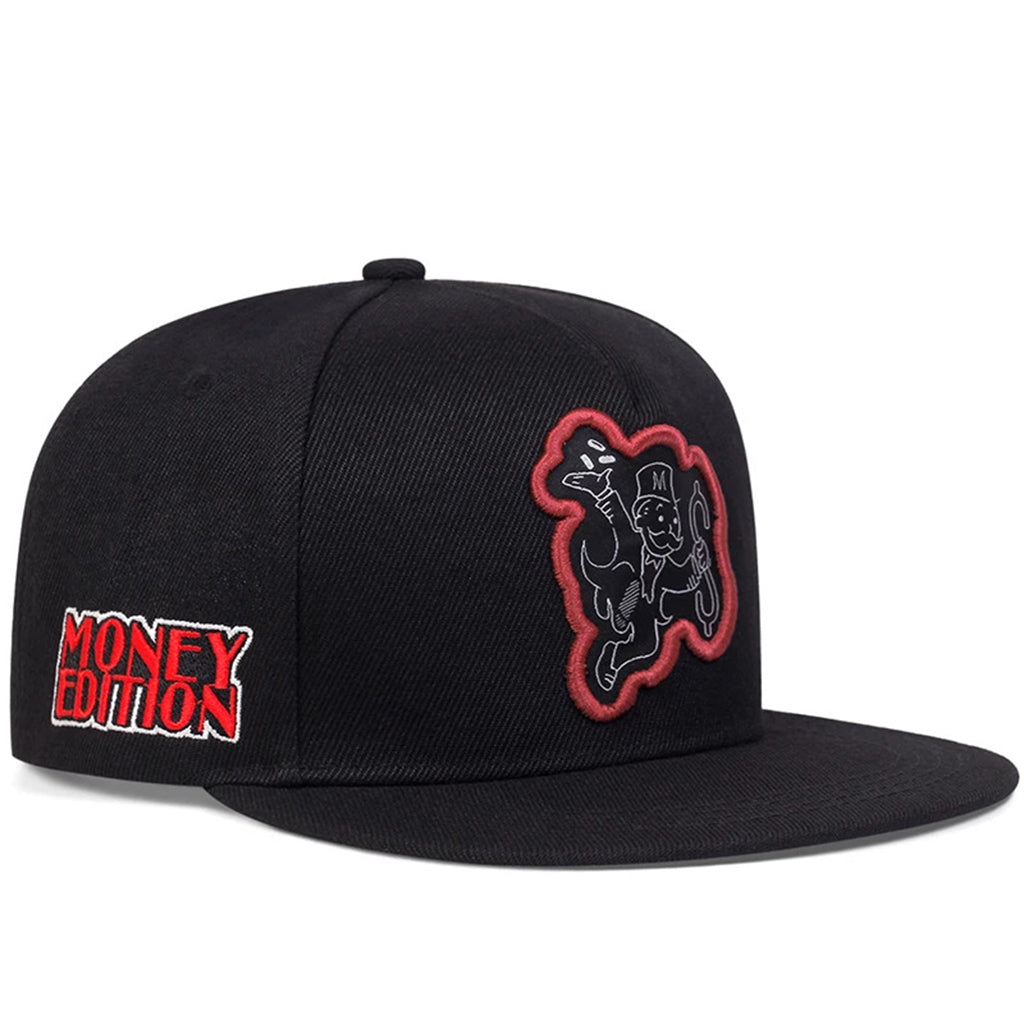 Svart snapback keps med den ikoniska Monopol-gubben i hög hatt, springande med pengar och hållande i ett dollartecken
